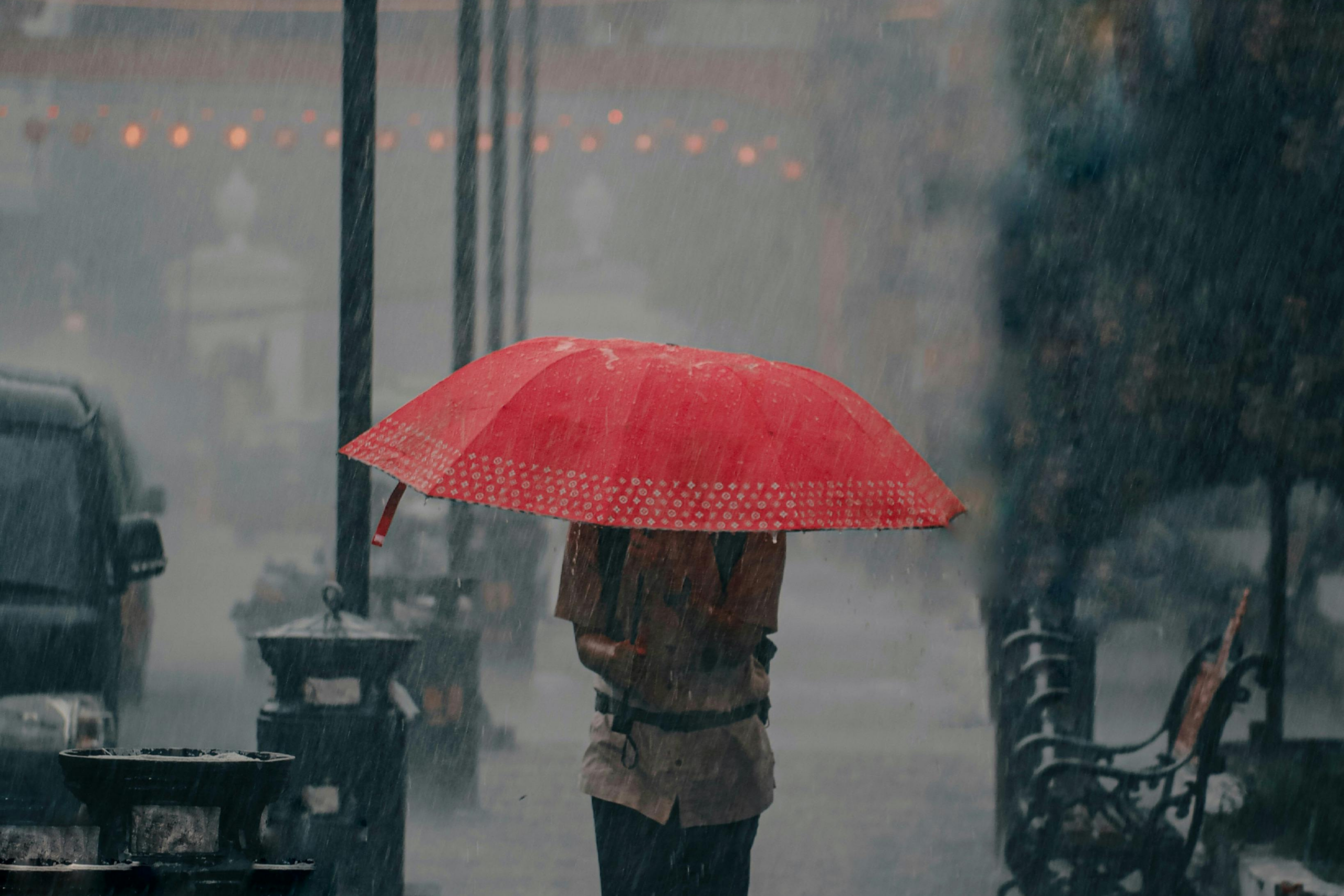 man with a red umbrella in the rainstorm